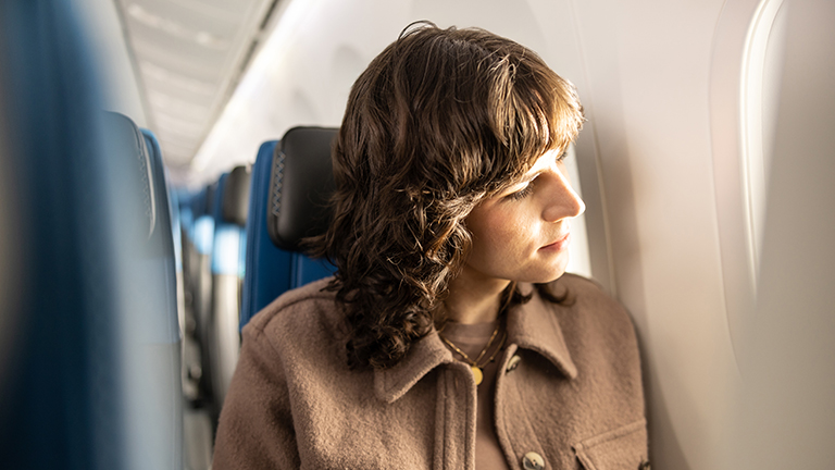 Guest looking out airplane window