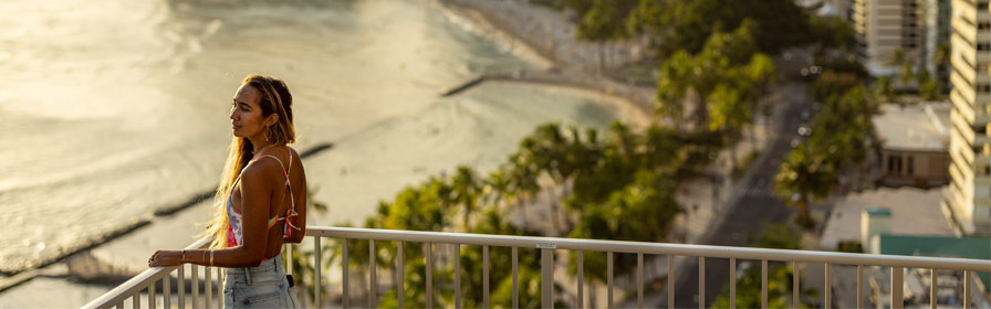 Person gazing at ocean from balcony at The Twin Fin in Waikiki