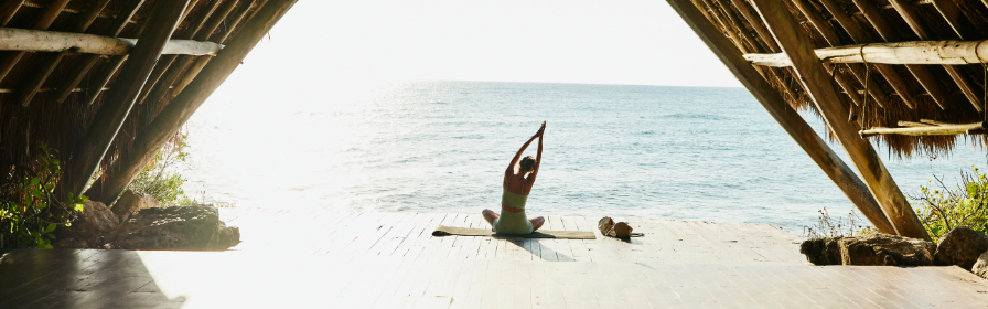 Personne faisant du yoga sur une plage du Mexique