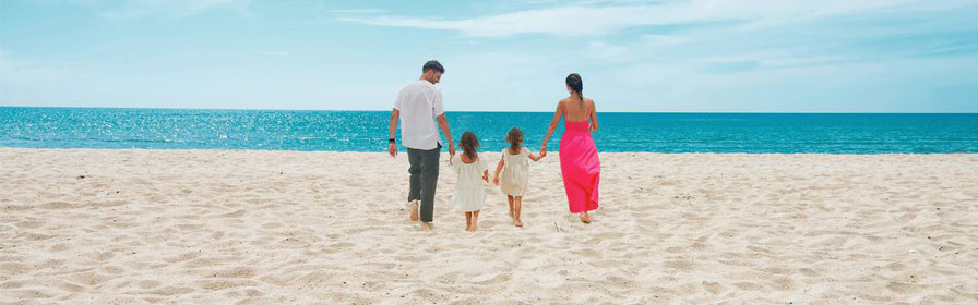 Famille marchant sur la plage vers l’océan