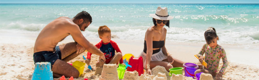 Famille construisant des châteaux de sable au Seadust Cancun Family Resort