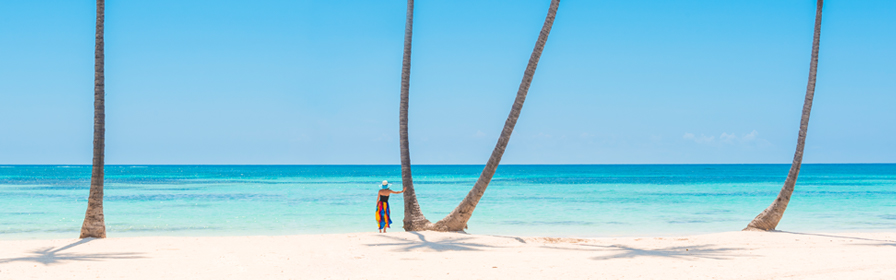 Person standing next to palm trees on beach in Punta Cana